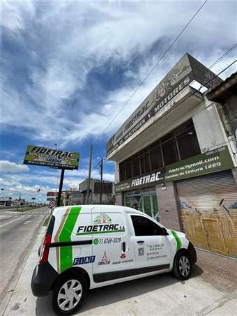 Fachada de Fidetrac S.A. con cartel de repuestos de tractores y motores y camioneta de reparto